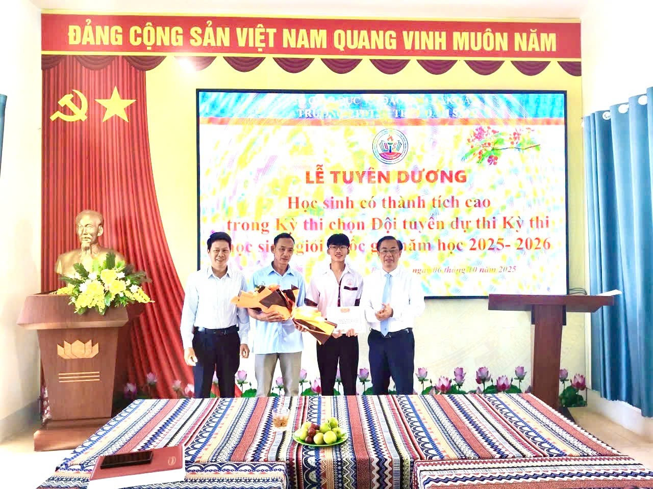 Ban Giám hiệu nhà trường chúc mừng, động viên em Nguyễn Thọ Hoàng Anh, học sinh giỏi môn Địa lí. (Ảnh: ĐTN)